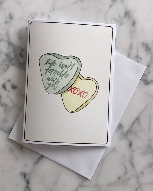 A candy hearts Valentine's Day card with a little bit of sass and text that says "life isn't terrible with you, XOXO"