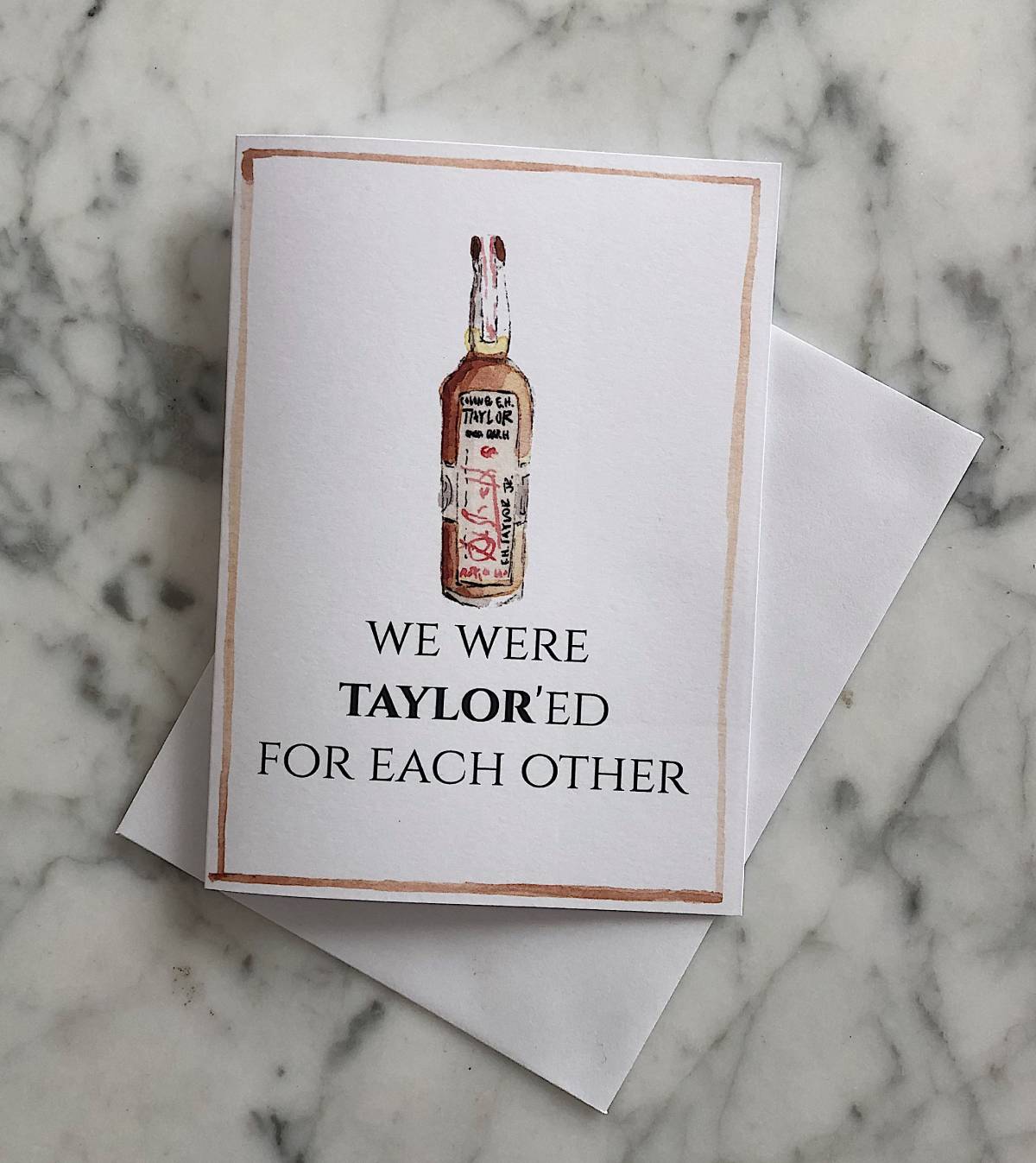 A white bourbon Valentine's Day card with a watercolor illustration of an EH Taylor bourbon bottle with the text "We were taylor'ed for each other"