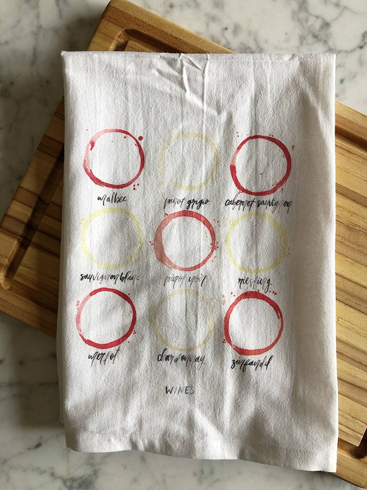 A white tea towel displaying watercolor illustrations of 9 different types of wines as wine ring stains