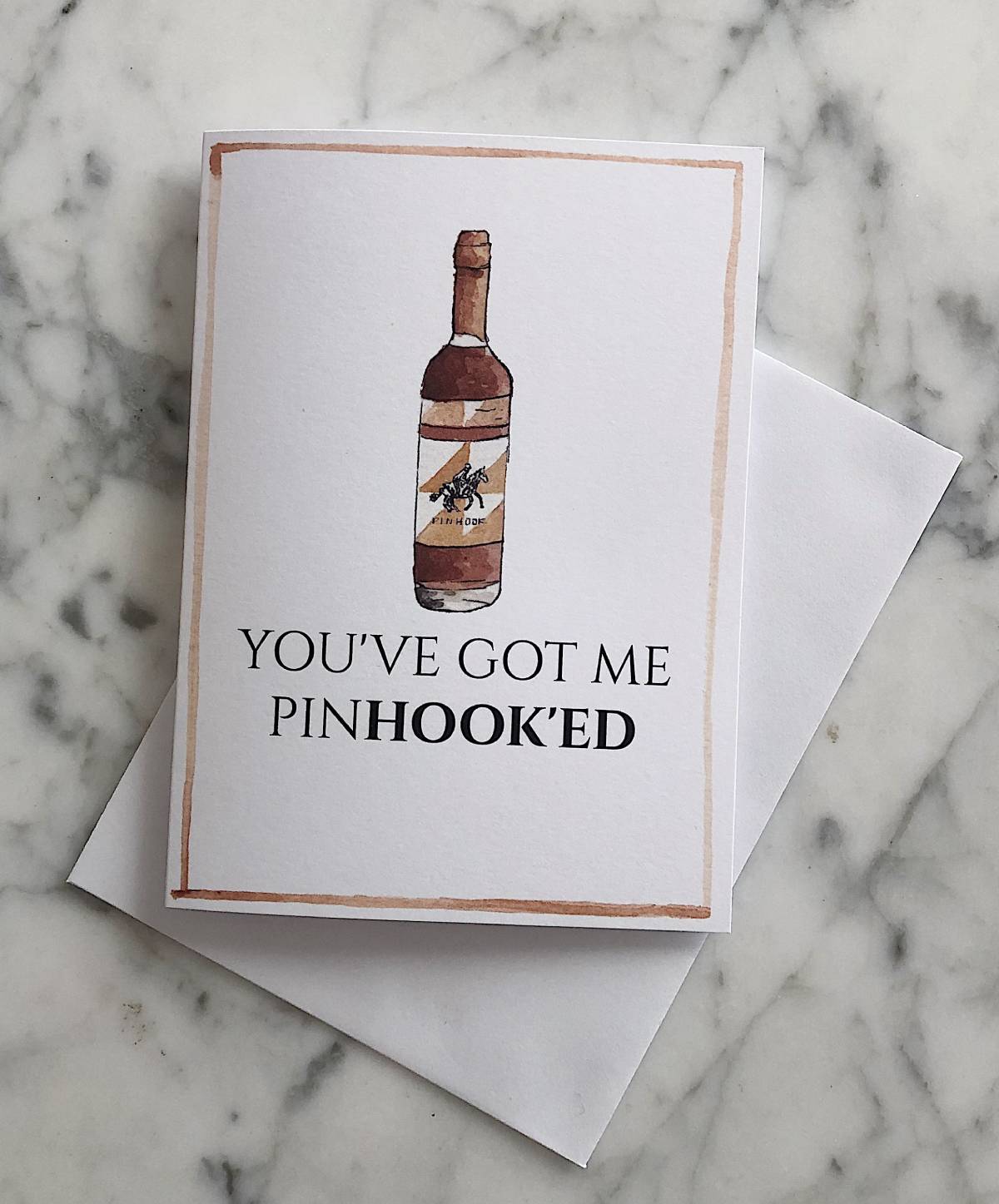 A white bourbon Valentine's Day card with an illustration of Pinhook bourbon and the text "you've got me pinhook'ed"