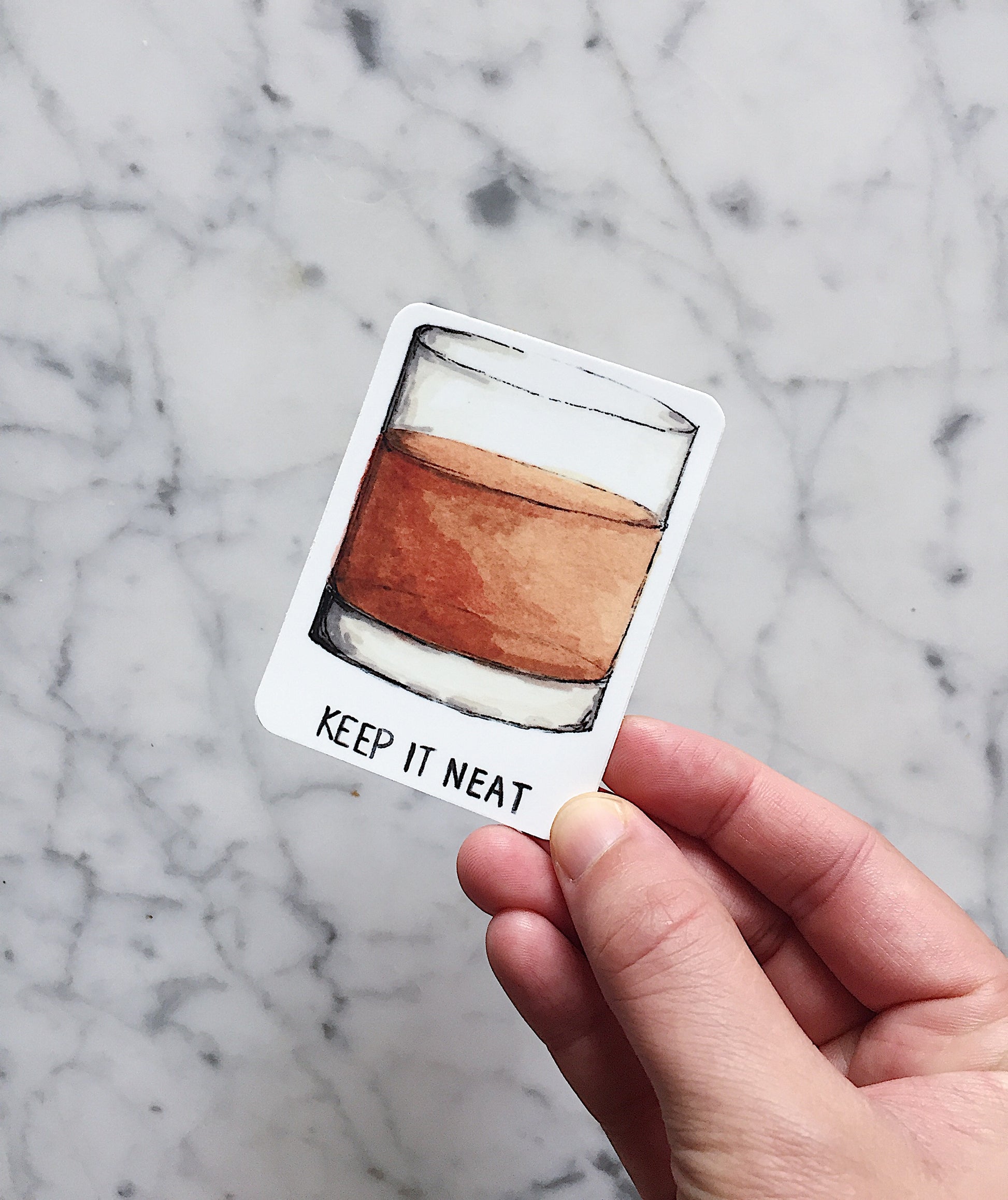 An incredibly fun sticker for the bourbon lover that displays a watercolor illustration of a neat glass of bourbon with the phrase "keep it neat" beneath the glass.